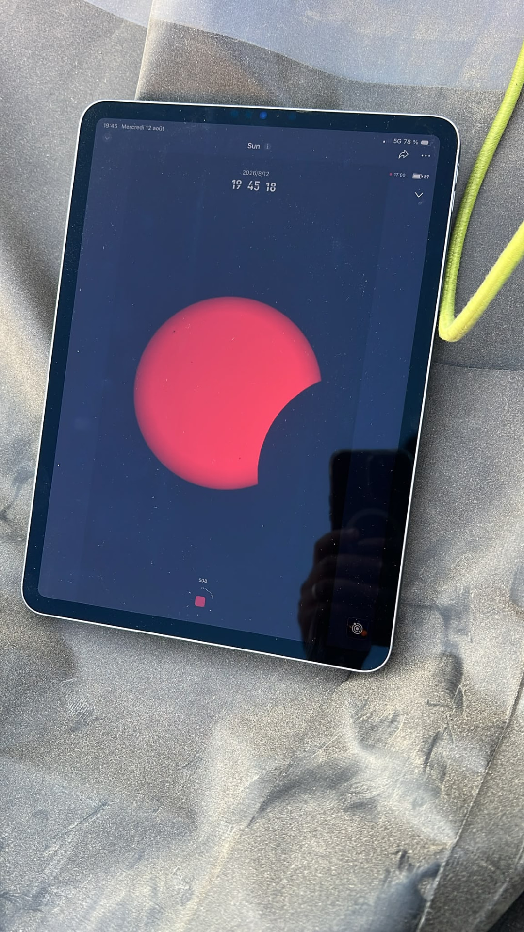 La tablette affiche l’image du Seestar S50 à 19 h 45, avec une partie du disque solaire masquée par la Lune